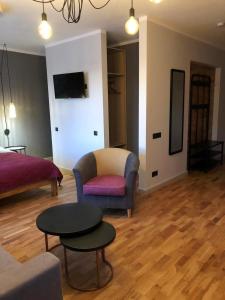 een woonkamer met een bank, een stoel en een tafel bij Kaktuss apartamenti Smiltene in Smiltene