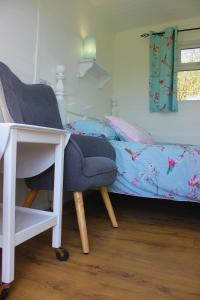 a bedroom with a desk and a chair and a bed at Hopgarden Glamping Luxury Shepherds Huts in Wadhurst