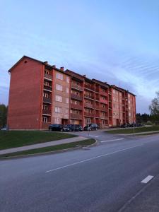 a large red brick apartment building on the side of a road at Kaktuss apartamenti Smiltene in Smiltene