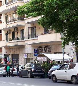 een straat met auto's geparkeerd voor een gebouw bij A casa di Robi in Rome