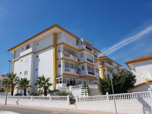 a large white and yellow building on a street at Park Beach La Mata in La Mata