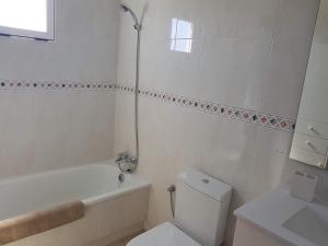 a white bathroom with a toilet and a tub and a sink at Park Beach La Mata in La Mata