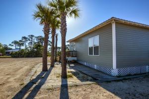 a house with palm trees in front of it at The Rookery III Unit 7024 Cottage in Gulf Shores