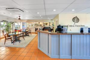 a restaurant with a counter and tables and chairs at Coral Tree Inn in Cairns