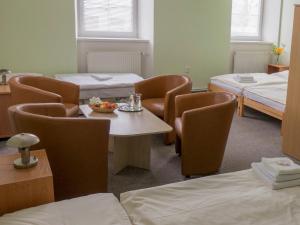 ジャツレールシにあるPension Žacléřský Medvědのベッド2台、テーブル、椅子が備わる客室です。
