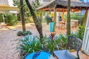 patio ze stołem i krzesłami oraz pawilonem w obiekcie Coral Tree Inn w mieście Cairns