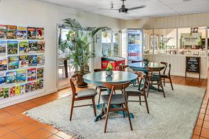un restaurante con mesas, sillas y una barra en Coral Tree Inn, en Cairns