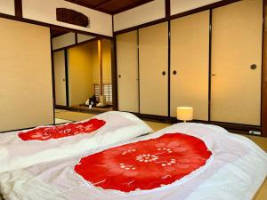 two beds in a large room with mirrors at Private reservation near KIX "Wakeikan" in Hannan