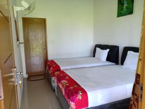 two beds sitting next to each other in a room at Rosalina Homestay in Rantepao