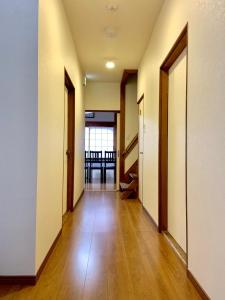 an empty hallway with doors and a table at Waraku No2,Guesthouse near KIX in Izumi-Sano