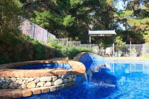 a swimming pool with a stone retaining wall and a swimming pool at Bright River Rest in Bright