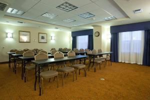 a conference room with tables and chairs and a clock at Country Inn & Suites by Radisson, Texarkana, TX in Texarkana