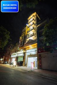 a tall building with lights on it at night at An loc hotel in Diện Biên Phủ