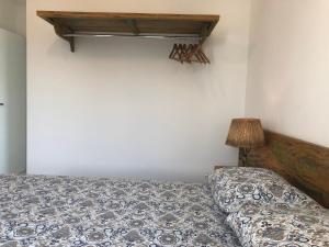 a bedroom with a bed and a table and a lamp at Cobertura em Ubatuba in Ubatuba