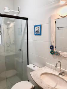 a bathroom with a shower and a toilet and a sink at Cobertura em Ubatuba in Ubatuba