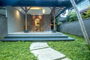 a house with a porch with a table and stairs at A4K Sanggingan Villa in Ubud