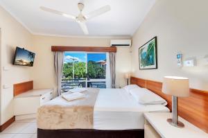 a bedroom with a bed and a balcony at Tropical Queenslander in Cairns