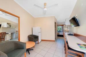 cocina y sala de estar con mesa y nevera en Tropical Queenslander, en Cairns