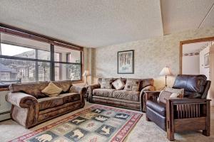 a living room with couches and a couch and a chair at Vs438 Village Square Condo in Copper Mountain
