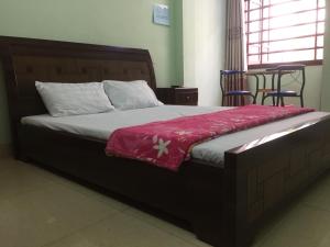ein Schlafzimmer mit einem Bett mit einer roten Decke darauf in der Unterkunft Hân hân in Hạ Long