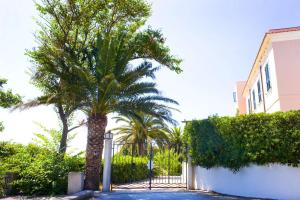 a gate with a palm tree in front of a building at Villa Penelope in San Felice Circeo