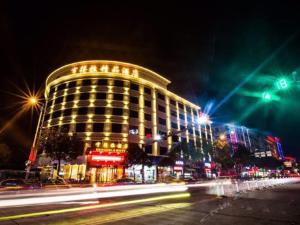 a building at night with lights on a street at Hendra Hotel in Wenzhou