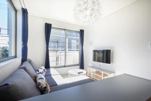 ein Wohnzimmer mit einem Sofa und einem TV in der Unterkunft koiwa house 3LDK free wifi free parking in Tokio