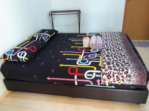 a black bed with colorful pillows on top of it at Matleon village in Jerantut