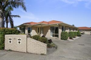 een huis met een bakstenen hek ervoor bij Tondo in Lakes Entrance