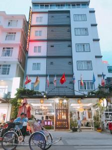 Ein Mann, der vor einem Hotel Fahrrad fährt in der Unterkunft Golden Star Hotel in Hue