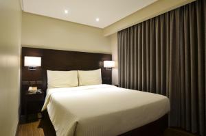 Postel nebo postele na pokoji v ubytování Pearl Garden Hotel