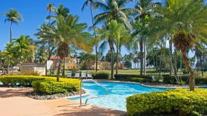 una piscina con palmeras en un complejo en Palm View, en Humacao