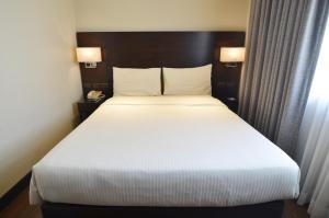 Postel nebo postele na pokoji v ubytování Pearl Garden Hotel
