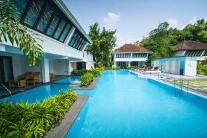a swimming pool in front of a building at Nihara Resort and Spa Cochin in Cochin