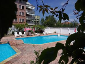 a swimming pool with chairs and a building at Ethno guest suite in Primorsko