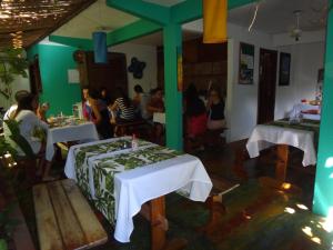 a group of people sitting at tables in a restaurant at Pousada Maresia in Itacaré
