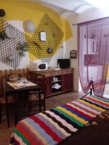 1 dormitorio con mesa y 1 cama con una manta colorida en Agriturismo Alla Mal Parata, en Albenga