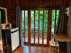 a kitchen with a sliding glass door to a porch at Rustic​ Charm​ Suphan​ in Ban Tha Pong