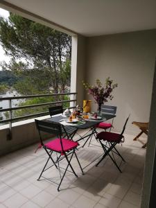 a table and four chairs on a balcony with a table and a window at Tee 4 in Nîmes