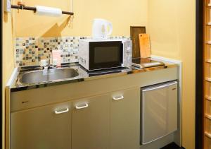 un comptoir de cuisine avec un évier et un micro-ondes dans l'établissement Rinn Kujoharikoji 59, à Kyoto