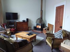 a living room with couches and a wood stove at The Villa in Oamaru