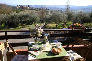 una mesa con un plato de comida y flores en ella en Casa Milena, en San Gimignano