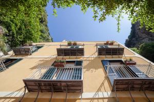 a building with three balconies with plants on it at Hotel L'Argine Fiorito in Atrani