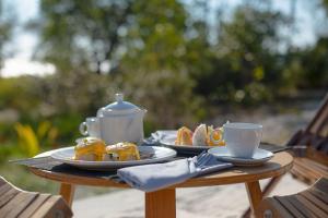 a table with two plates of food and cups on it at Tamu Koh Rong in Koh Rong Island