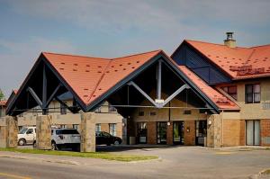 un gran edificio con techo rojo en Thompson's Best Value Inn & Suites, en Thompson