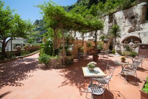 a patio with a table and chairs and trees at Hotel L'Argine Fiorito in Atrani