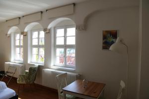 a living room with a table and windows at Domblick an der Freiheit in Meißen