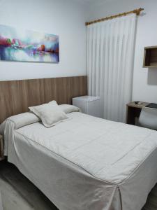 a bedroom with a bed and a table and a painting at Hotel La Posada in La Palma