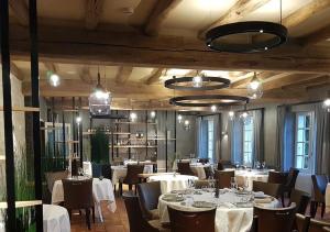 a dining room with white tables and chairs at Logis Auberge De La Riviere in Velluire