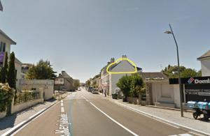 Una calle vacía con un cartel de flecha amarilla. en Le P'tit Cocoon, en Lorient